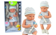 Baby doll in blue and white clothes, hat, pacifier, bib, quilt